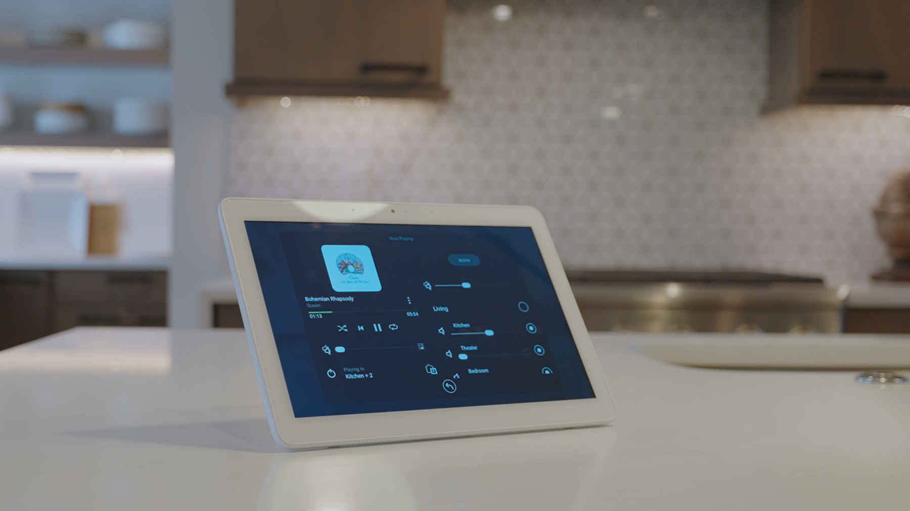 A control tablet on a kitchen counter showing audio and lighting controls for the whole house.